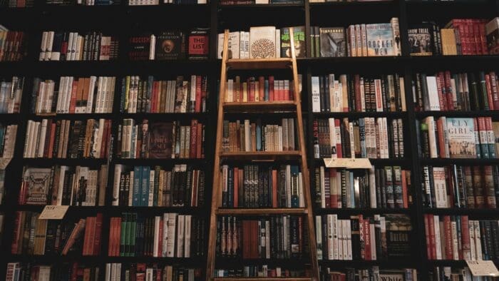 A Library with a ladder against the shelves of books